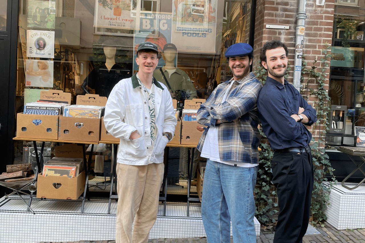 Mannen staan geposeerd voor de winkel
